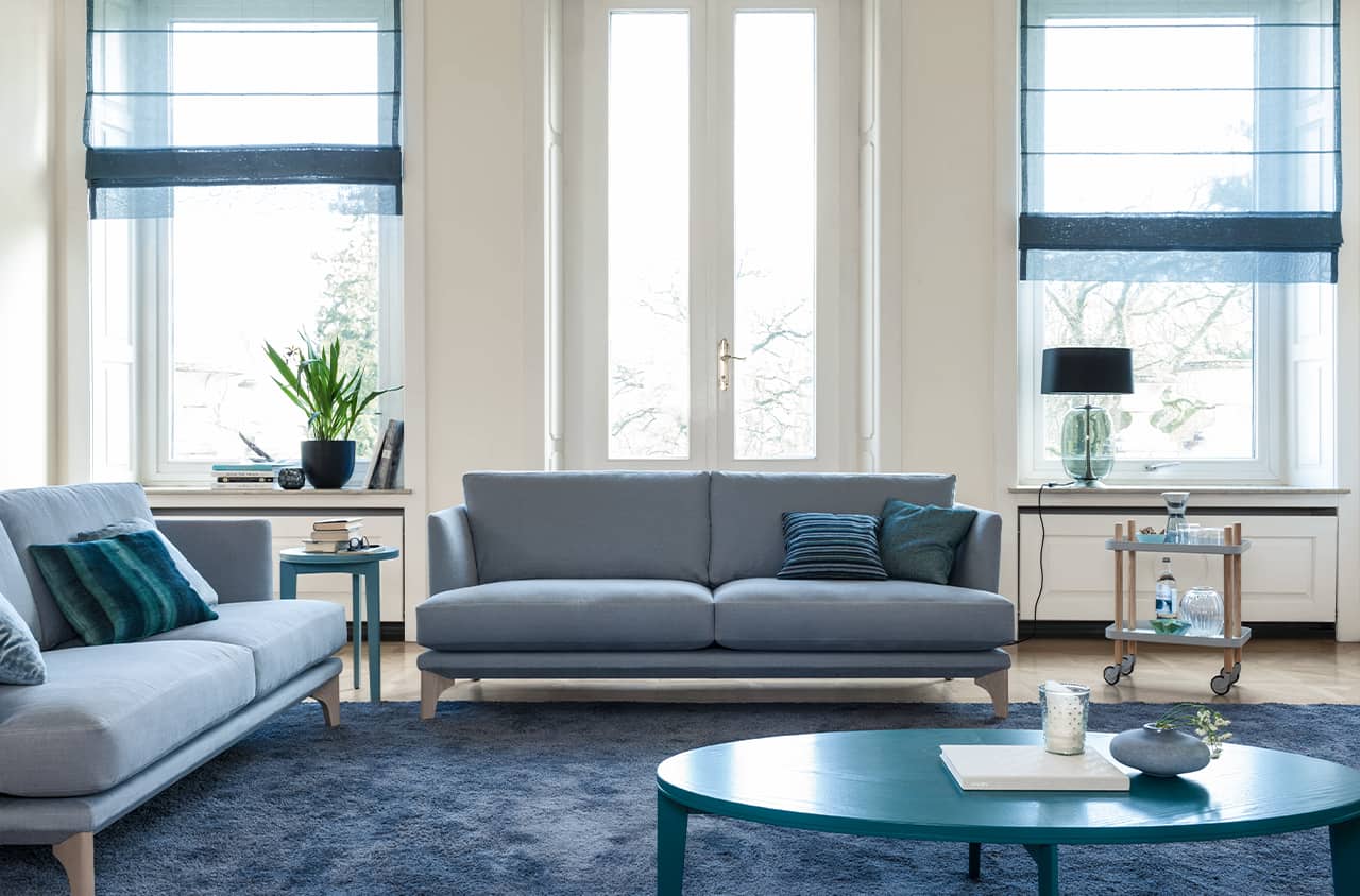 Klares Sofa in sanftem Blau mit ruhiger, moderner Ausstrahlung.